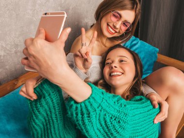 İki genç gülümseyen güzel kızlar trendy yaz hipster giysileri güzel. Seksi kaygısız kadın iç ve alma selfie poz. Olumlu modelleri smartphone ile eğleniyor