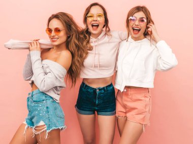 Üç genç güzel gülümseyen hippi kız trendy yaz hipster giysileri. Seksi kaygısız kadınlar, pembe arka plan poz. Olumlu modelleri eğleniyor