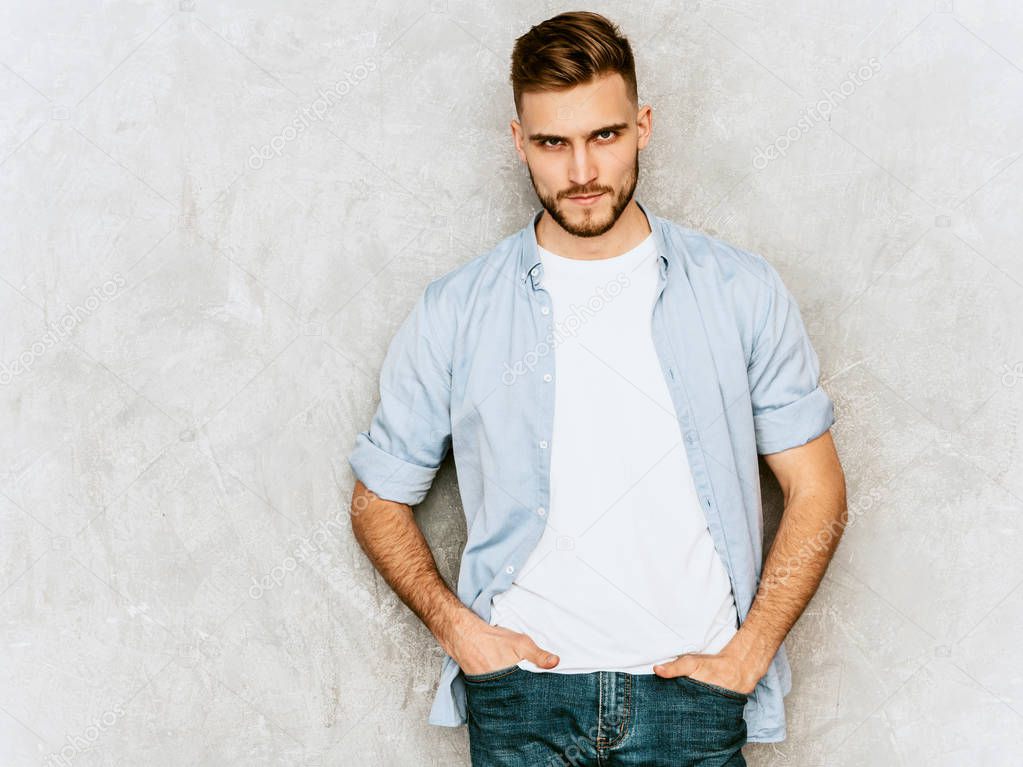 Portrait of handsome hipster lumbersexual businessman model wearing casual shirt clothes. Fashion stylish man posing against gray wall