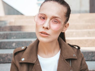 Yaz hipster ceket giysilergiymiş güzel esmer model portresi. Sokak arka planda poz veren modaya uygun bir kız. Yuvarlak güneş gözlüğü komik ve pozitif kadın