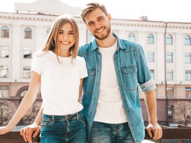 Gülümseyen güzel kız ve rahat yazlık giysiler onun yakışıklı erkek arkadaşı. Mutlu neşeli aile sokak arka planda eğlenmek 