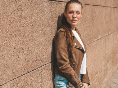 Yaz hipster ceket giysilergiymiş güzel esmer model portresi. Duvara yakın sokakta poz veren modaya uygun kız. Yuvarlak güneş gözlüğü komik ve pozitif kadın