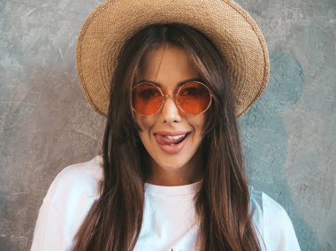 Kameraya bakan genç güzel gülümseyen kadın Closeup portraif. Rahat yazlık giysiler ve şapka trendy kız. Pozitif kadın komik yüz yapma ve dil gösteren