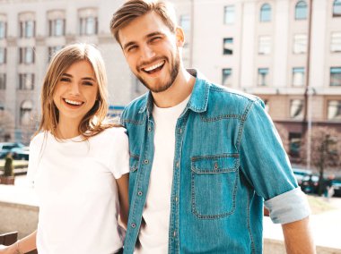 Rahat yazlık giysiler içinde gülümseyen güzel kız ve onun yakışıklı erkek arkadaşı Portresi. Mutlu neşeli aile sokak arka planda eğlenmek. Sarılma