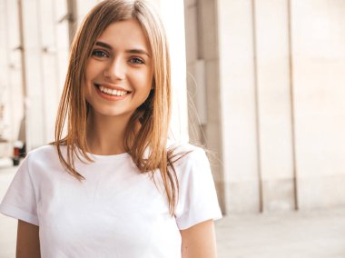 Yaz hipster giysileri giymiş güzel gülümseyen sarışın model portresi. Sokak arka planda poz veren modaya uygun bir kız. Komik ve pozitif kadın eğleniyor