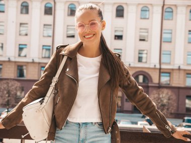 Yaz hipster ceket giysiler giymiş güzel gülümseyen esmer model portresi. Sokak arka planda poz veren modaya uygun bir kız. Yuvarlak güneş gözlüğü komik ve pozitif kadın