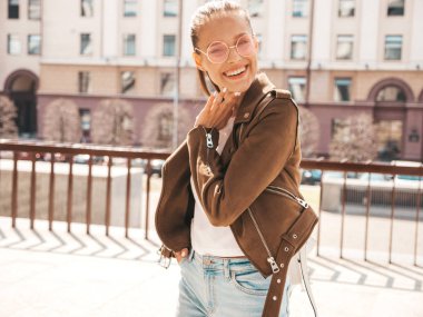 Yaz hipster ceket giysiler giymiş güzel gülümseyen esmer model portresi. Sokak arka planda poz veren modaya uygun bir kız. Yuvarlak güneş gözlüğü komik ve pozitif kadın