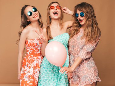 Üç yaz hipster güzel kadınların gülümseyen Giydir. Altın arka plan üzerinde poz kızlar. Modelleri renkli hava balonları ile. Eğleniyor, kutlama Doğum günü veya tatil parti için hazır