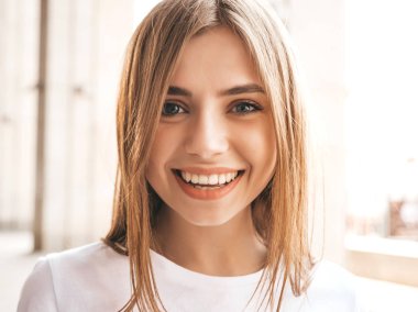 Yaz hipster giysileri giymiş güzel gülümseyen sarışın model portresi. Sokak arka planda poz veren modaya uygun bir kız. Komik ve pozitif kadın eğleniyor