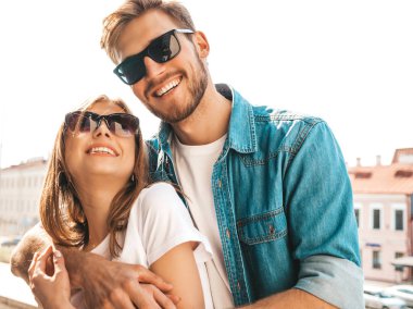 Gülümseyen güzel kız ve onun yakışıklı erkek arkadaşı Portresi. Rahat yazlık kot elbiseli kadın. Mutlu neşeli bir aile. Kadın güneş gözlüğü sokak arka planda eğlenmek