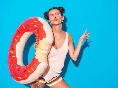 Güneş gözlüğü genç güzel seksi gülümseyen hipster kadın. Donut lilo şişme yatak ile yazlık giysiler kız. Pozitif kadın deliriyordu. Mavi üzerine izole edilmiş komik bir model. Barış işaretini gösterir