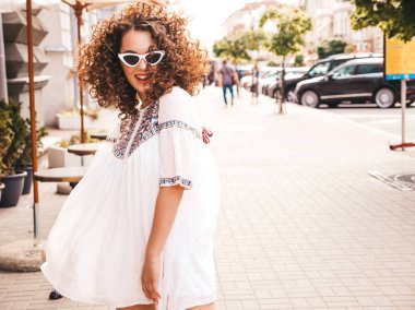 Yaz hipster beyaz elbise giymiş afro bukleler saç modeli ile güzel gülümseyen model. Seksi kaygısız kız sokak arka planda poz. Trendy komik ve pozitif kadın güneş gözlüğü eğlenmek
