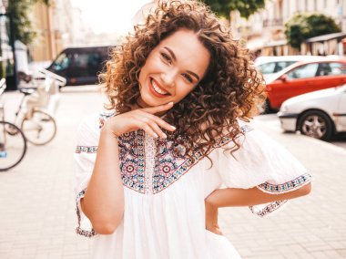 Yaz hipster beyaz elbise giymiş afro bukleler saç modeli ile güzel gülümseyen model portresi. Seksi kaygısız kız sokak arka planda poz. Trendy komik ve olumlu kadın eğleniyor