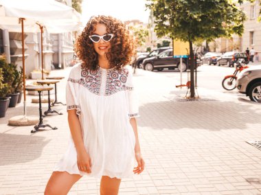 Yaz hipster beyaz elbise giymiş afro bukleler saç modeli ile güzel gülümseyen model. Seksi kaygısız kız sokakta poz. Trendy komik ve pozitif kadın güneş gözlüğü eğlenmek