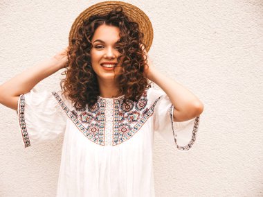 Yaz hipster beyaz elbise giymiş afro bukleler saç modeli ile güzel gülümseyen model. Seksi kaygısız kız şapka beyaz duvar yakınında sokakta poz. Komik, pozitif kadın eğleniyor ve delioluyor