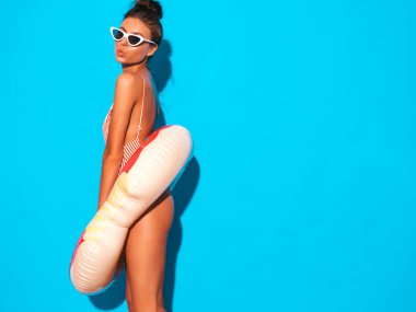 Güneş gözlüğü genç güzel seksi gülümseyen hipster kadın. Donut lilo şişme yatak ile yaz mayo mayo Kız. Pozitif kadın deliriyordu. Mavi duvarın yakınında poz vermek