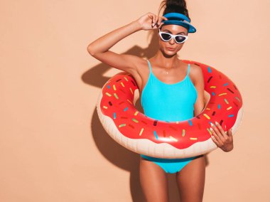 Güneş gözlüğü genç güzel seksi gülümseyen hipster kadın. Donut lilo şişme yatak ile yaz mayo mayo Kız. Pozitif kadın deliriyordu. Şeffaf vizör kapağı bej duvar ayakın