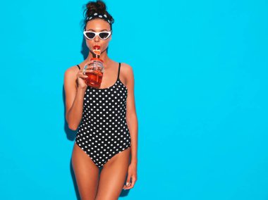Güneş gözlüğü genç güzel seksi gülümseyen hipster kadın. Yaz bezelye mayosu kız. Mavi duvarın yakınında poz vermek, taze kokteyl içen smoozy içecek