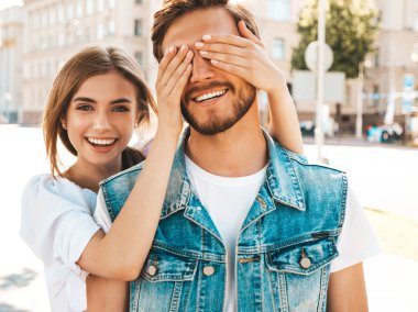 Gülümseyen güzel kız ve onun yakışıklı hipster erkek arkadaşı. Kadın erkek gözlerini elleriyle kapatıyor. Mutlu neşeli bir aile. Dışarıda duran sevgi dolu çifte sarılıyorlar. Bil bakalım kim kavramı 