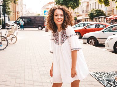 Yaz hipster beyaz elbise giymiş afro bukleler saç modeli ile güzel gülümseyen model portresi. Seksi kaygısız kız sokak arka planda poz. Trendy komik ve olumlu kadın eğleniyor