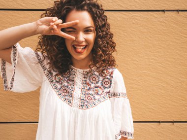 Yaz hipster beyaz elbise giymiş afro bukleler saç modeli ile güzel gülümseyen model. Seksi kaygısız kız sarı duvara yakın sokakta poz. Komik ve pozitif kadın eğleniyor