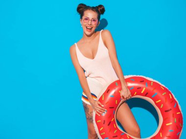 Güneş gözlüğü genç güzel seksi gülümseyen hipster kadın. Donut lilo şişme yatak ile yazlık giysiler kız. Pozitif kadın deliriyordu. Mavi izole komik model