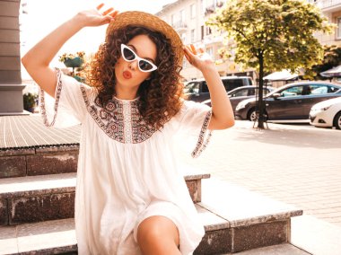 Yaz hipster beyaz elbise giymiş afro bukleler saç modeli ile güzel gülümseyen model. Seksi kaygısız kız sokakta poz. Trendy ve pozitif kadın güneş gözlüğü eğlenmek. Şapkalı
