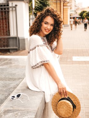 Yaz hipster beyaz elbise giymiş afro bukleler saç modeli ile güzel gülümseyen model. Seksi kaygısız kız sokakta poz. Trendy komik ve olumlu kadın şapka eğlenmek