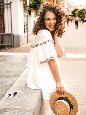 Yaz hipster beyaz elbise giymiş afro bukleler saç modeli ile güzel gülümseyen model. Seksi kaygısız kız sokakta poz. Trendy komik ve olumlu kadın şapka eğlenmek