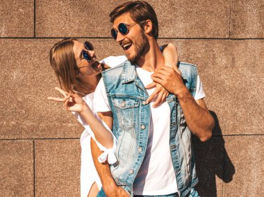 Gülümseyen güzel kız ve yakışıklı erkek arkadaşı. Günlük yazlık elbiseli bir kadın. Kot pantolonlu bir adam. Mutlu mutlu bir aile. Duvarın yanında eğlenen bir kadın.