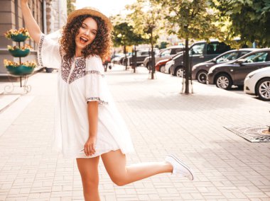 Yaz hipster beyaz elbise giymiş afro bukleler saç modeli ile güzel gülümseyen model portresi. Seksi kaygısız kız sokak arka planda poz. Şapka trendy komik ve pozitif kadın