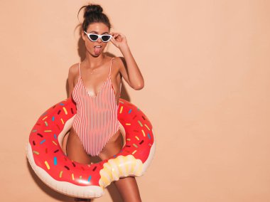 Güneş gözlüğü genç güzel seksi gülümseyen hipster kadın. Donut lilo şişme yatak ile yaz mayo mayo Kız. Pozitif kadın deliriyordu. Şeffaf vizör kapağı bej duvar ayakın