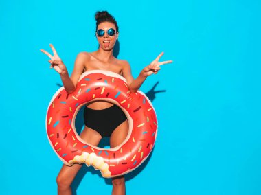 Güneş gözlüğü genç güzel seksi gülümseyen hipster kadın. Yazlık mayo giyen kız. Donut lilo şişme yatak ile göğsünü kapatır. Pozitif kadın deliriyordu. Mavi duvarın yakınında poz vermek
