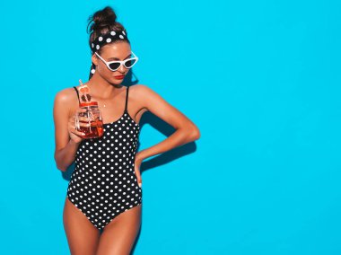 Güneş gözlüğü genç güzel seksi gülümseyen hipster kadın. Yaz bezelye mayosu kız. Mavi duvarın yakınında poz vermek, taze kokteyl içen smoozy içecek