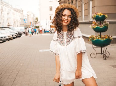 Yaz hipster beyaz elbise giymiş afro bukleler saç modeli ile güzel gülümseyen model. Seksi kaygısız kız sokakta poz. Trendy komik ve pozitif kadın güneş gözlüğü eğlenmek