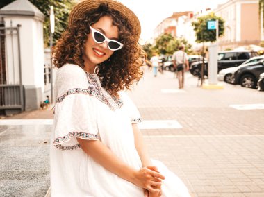 Yaz hipster beyaz elbise giymiş afro bukleler saç modeli ile güzel gülümseyen model. Seksi kaygısız kız sokakta poz. Trendy ve pozitif kadın güneş gözlüğü eğlenmek
