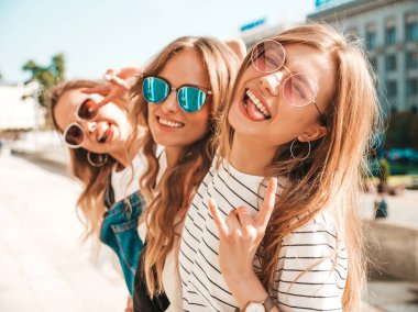 Moda yazlık giysiler üç genç güzel gülümseyen hipster kız Portresi. Seksi kaygısız kadınlar sokak arka planda poz. Güneş gözlüğü ile eğlenen pozitif modeller. Sarılma
