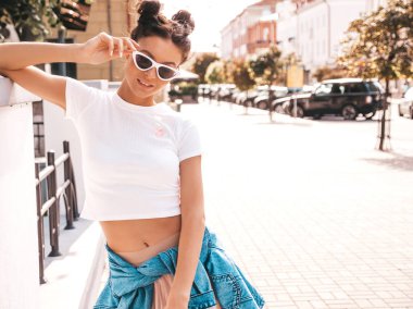 Boynuzları saç modeli yaz hipster ceket kot elbise giymiş güzel gülümseyen model. Seksi kaygısız kız sokak arka planda poz. Trendy komik ve pozitif kadın güneş gözlüğü eğlenmek