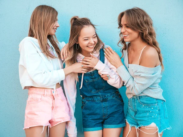 三个年轻美丽的微笑嬉皮士女孩在时髦的夏季服装的肖像 性感的女人在蓝色墙附近的街道上摆姿势 积极模型有乐趣 他们交流和讨论某事 — 图库照片