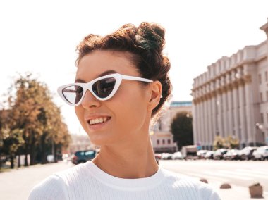 Boynuzları saç modeli yaz hipster giysiler giymiş güzel gülümseyen model. Seksi kaygısız kız sokak arka planda poz. Trendy komik ve pozitif kadın güneş gözlüğü eğlenmek