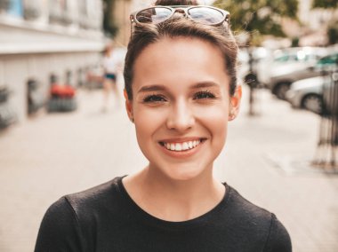 Yaz giysileri giymiş güzel gülümseyen hipster modeli portresi. Sokak arka planda poz veren modaya uygun bir kız. Komik ve pozitif kadın eğleniyor