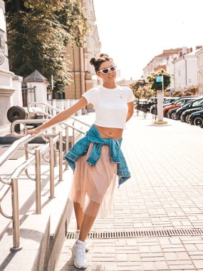 Boynuzları saç modeli yaz hipster ceket kot elbise giymiş güzel gülümseyen model. Seksi kaygısız kız sokak arka planda poz. Trendy komik ve pozitif kadın güneş gözlüğü eğlenmek