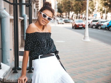 Zarif yazlık giysiler giymiş güzel gülümseyen model. Sokak arka planda oturan seksi kaygısız kız. Güneş gözlüğü trendy modern iş kadını eğlenmek