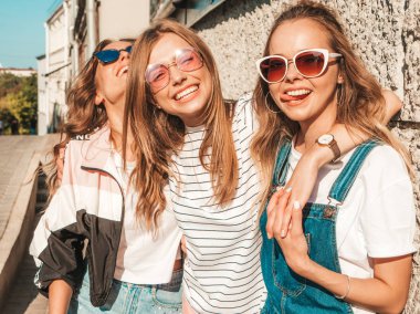 Moda yazlık giysiler üç genç güzel gülümseyen hipster kız Portresi. Seksi kaygısız kadınlar sokak arka planda poz. Güneş gözlüğü ile eğlenen pozitif modeller. Sarılma