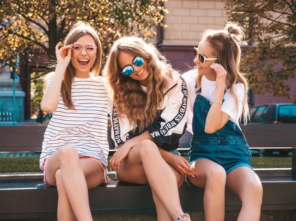 トレンディな夏の服を着た3人の若い美しい笑顔のヒップスターの女の子の肖像画 ストリートの背景にポーズセクシーな気楽な女性 サングラスで楽しいポジティブなモデル 抱いて — ストック写真