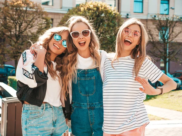トレンディな夏の服を着た3人の若い美しい笑顔のヒップスターの女の子の肖像画 ストリートの背景にポーズセクシーな気楽な女性 サングラスで楽しいポジティブなモデル 抱いて — ストック写真