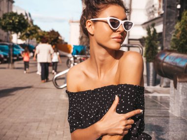 Zarif yazlık giysiler giymiş güzel gülümseyen model. Sokak arka planda oturan seksi kaygısız kız. Güneş gözlüğü trendy modern iş kadını eğlenmek