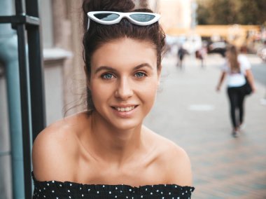 Zarif yazlık giysiler giymiş güzel gülümseyen model. Sokak arka planda oturan seksi kaygısız kız. Güneş gözlüğü trendy modern iş kadını eğlenmek