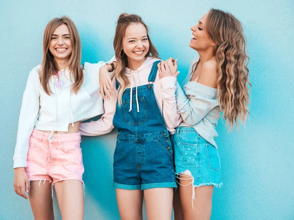 三个年轻美丽的微笑嬉皮士女孩在时髦的夏季服装的肖像 性感的女人在蓝色墙附近的街道上摆姿势 积极模型有乐趣 — 图库照片
