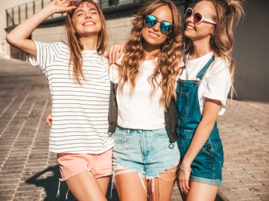 Moda yazlık giysiler üç genç güzel gülümseyen hipster kız Portresi. Seksi kaygısız kadınlar sokak arka planda poz. Güneş gözlüğü ile eğlenen pozitif modeller. Sarılma